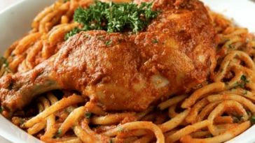 Disfruta de unos tallarines rojos con pollo y una deliciosa papa a la huancaína, un clásico peruano.