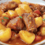 Disfruta de un plato tradicional con el sabor irresistible de las costillas y las patatas al horno.